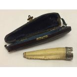 A vintage cased cherot holder with decorative white metal collar, made from crustacean claw.