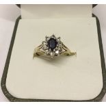 Ladies dress ring set with a sapphire surrounded by cubic zirconias. Weight approx 1.8g, size M.