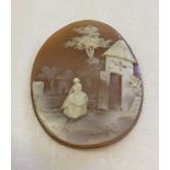 A 19th century cameo of a Lady in crinoline, farm/castle to background. 4 x 3cm.