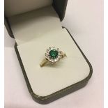 Ladies 9ct gold dress ring set with a central created emerald surrounded by cubic zirconias. Total