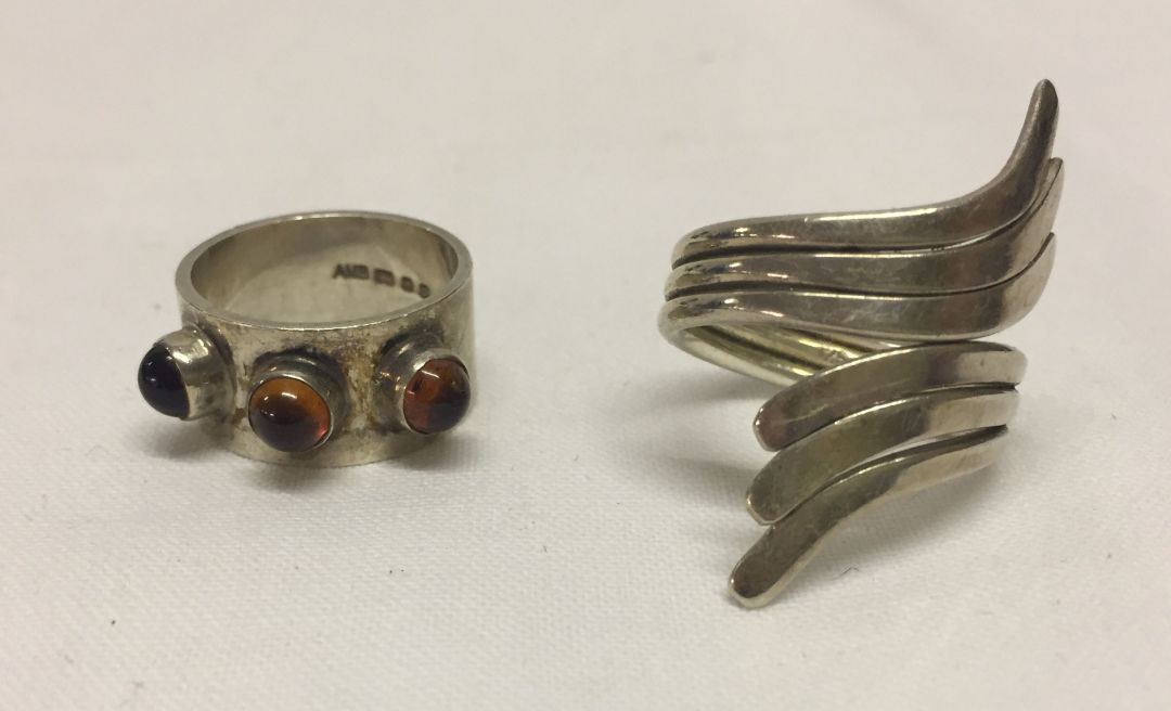 2 modern silver rings, one set with amber - size K1/2, and the other in a cross-over design - size