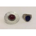 A Sterling silver brooch with carnelian stone set in the centre, measures approx 3cm across.