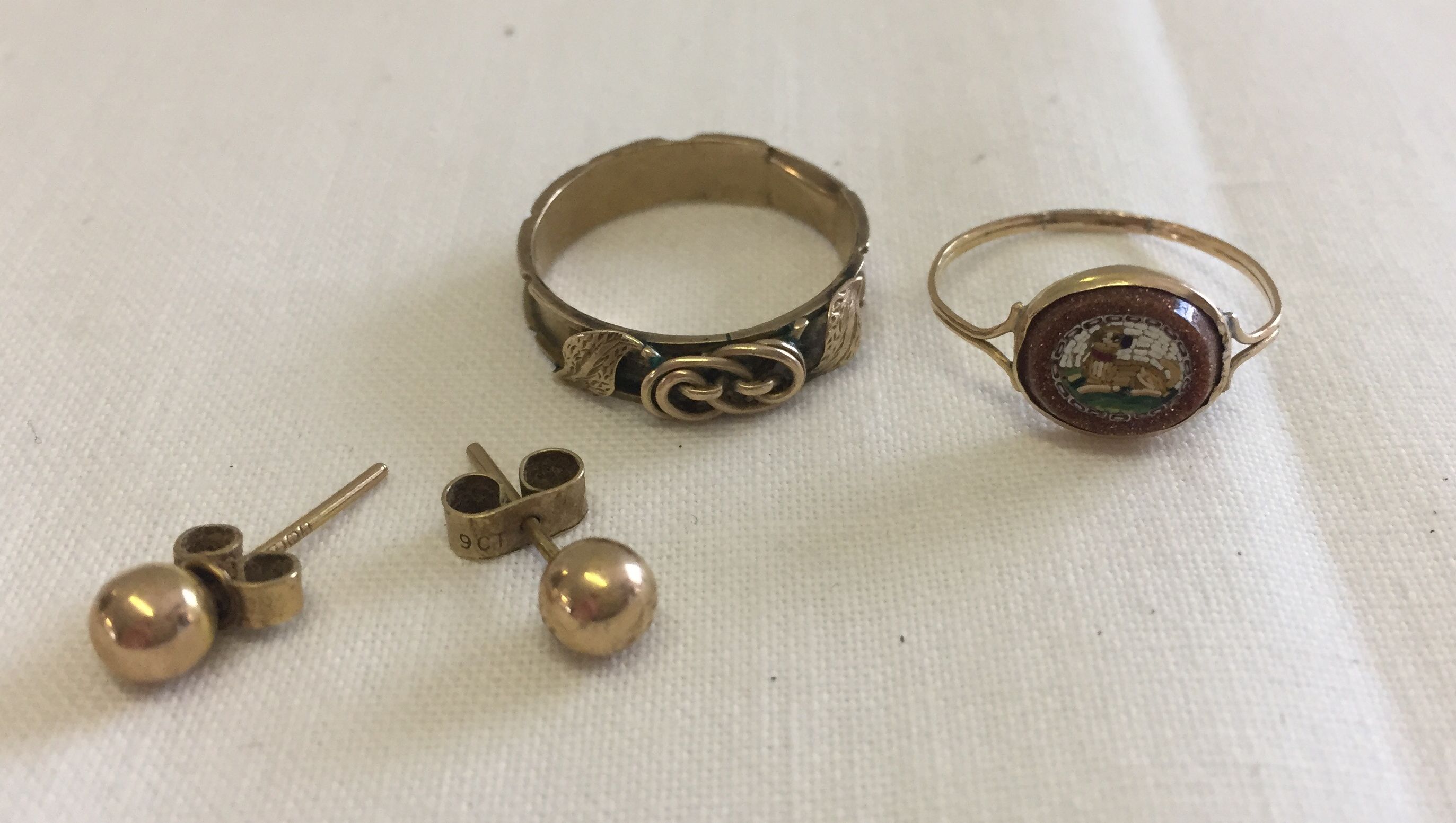 3 jewellery items to include a pair of 9ct gold stud earrings and pretty gold metal band ring.