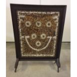 Fire screen with feather decoration under glass.