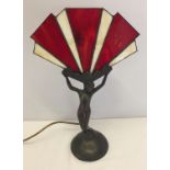 A metal based Art Deco style winged lady table lamp with red & cream leaded glass shade.