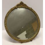 Round bevel edged mirror with gilt frame, approx 32cm across. Has stand on the back so can be