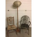 A rush seated ladder back chair together with a wheel back chair and wooden standard lamp.