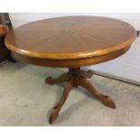 A light oak circular extending dining table on pedestal.