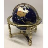 A reproduction globe mounted in a brass stand, set with semi precious stones and agates.