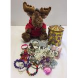 A musical tin with a Christmas theme containing childrens costume jewellery, together with a