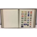 A green stamp album of stamps from around the world.