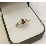 Pretty 9ct gold dress ring set with a central garnet and 2 cubic zirconias. Size M, total weight