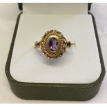 Hallmarked 9ct dress ring set with an oval amethyst stone set in a large decorative mount. Size N,