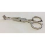 Hallmarked silver sugar scissors/nips with clam shell design. HM London 1939. Approx 10cm long.