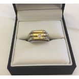 Gents ring in white & yellow gold set with a diamond. Marked 18KT, total weight approx 11.1g, size