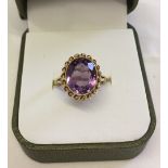 Hallmarked 9ct gold ring set with a large oval amethyst stone in a decorative setting. Size M, total