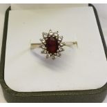 9ct gold dress ring set with a central oval garnet surrounded by cubic zirconias. Size P, total