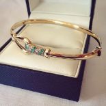 9ct gold bangle set with green and clear crystals. With clip over safety clasp. Total weight