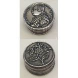 A small white metal patch/pill box. Double sided with George III on one side and a floral decoration
