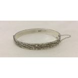 Solid hallmarked silver hinged bangle with safety chain.