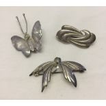 3 silver brooches, one in the shape of a butterfly.