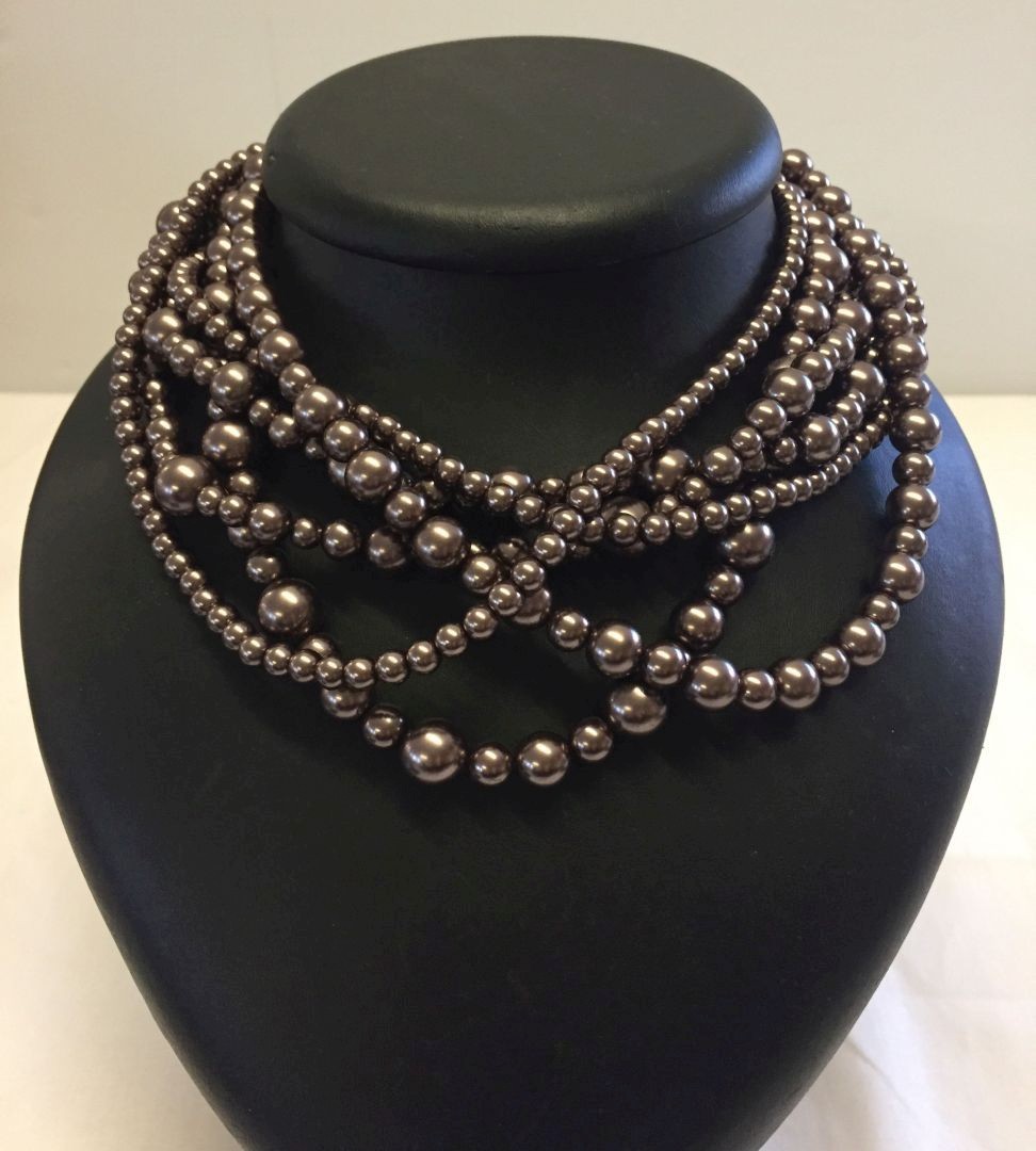 A 6 strand bead necklace with bronze colour beads of various sizes.