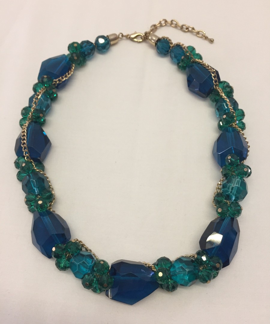 Statement necklace set with large faceted glass beads in teal and blue.