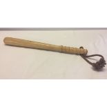 A light wood truncheon with rope handle.