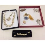 A quantity of costume jewellery to include necklace & earrings sets and brooches.