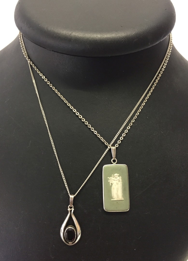 2 silver pendants on chains.