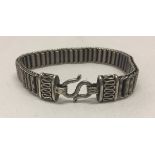 A decorative silver bracelet with hook clasp and coiled links.