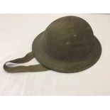 A WW2 British military helmet with liner & strap.