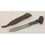 A vintage West Indian dagger with carved head decoration and wire handle.