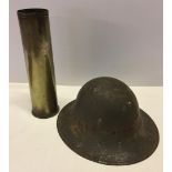 WW2 air raid wardens metal helmet together with a WW2 shell casing.