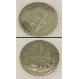 A silver 1935 George V crown coin.