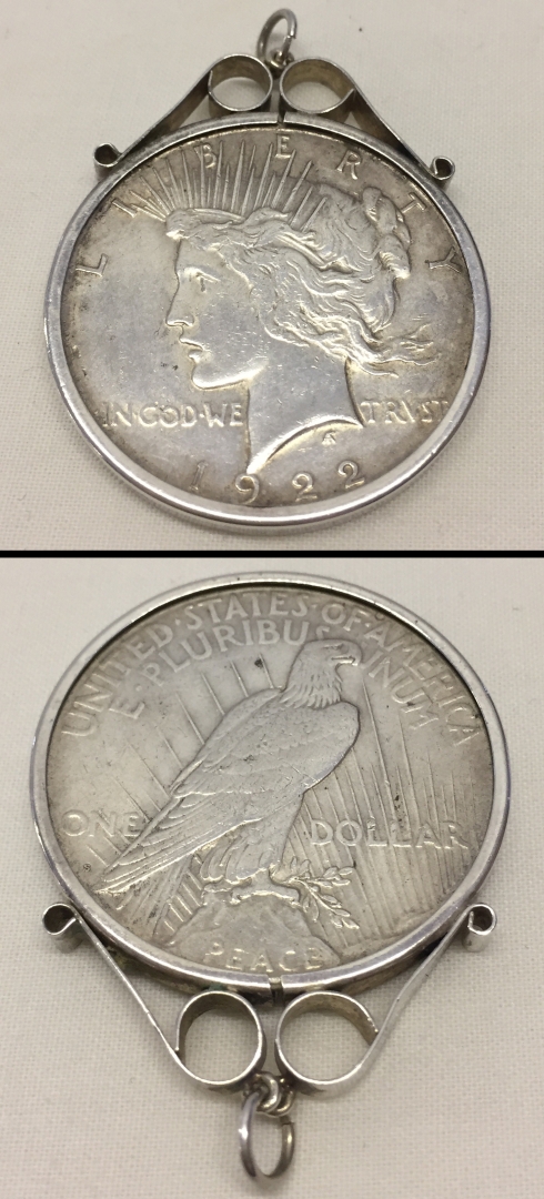 A 1922 American Peace silver dollar set in silver necklace mount.