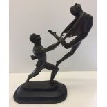 A large hollow bronzed figurine of ballet dancers on a marble base.