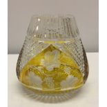 A cut glass bulbous vase with amber coloured overlay.