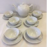 A Royal Copenhagen teapot with 6 cups & saucers. Half white lace pattern.