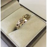 A 9ct gold ladies band ring in knotted design.