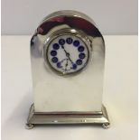 A hallmarked silver desk clock with enamelled dial.