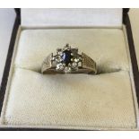 A 9ct gold ladies dress ring set with central sapphire surrounded by Cubic Zirconias.