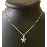 9ct white gold pendant in a flower design set with 5 blue topaz stones.