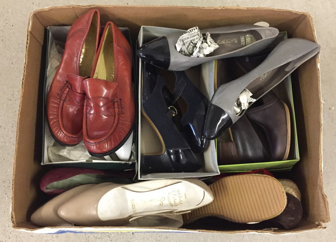 A box of vintage ladies shoes in autumnal colours.