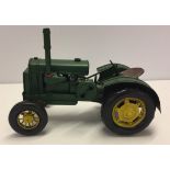 A reproduction tinplate yellow and green tractor.