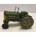 A vintage green and yellow tinplate tractor.