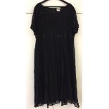 Calf-length black dress with sequin and beaded crepe. Compliments.