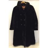 A ladies brown faux fur coat with fabric covered buttons.