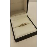 A 9ct gold diamond solitaire ring, set with 3 stones to each shoulder.