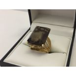 Ladies dress ring set with a very large baguette cut smokey quartz stone.